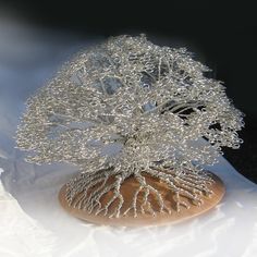 a wire tree sculpture sitting on top of a wooden base