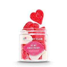 a jar filled with candy hearts on top of a white surface