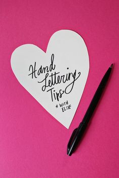 a heart shaped piece of paper with the words hand lettering tips on it and a black pen