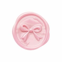 a pink wax stamp with a bow on the front and back of it's lid