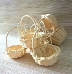 four wicker baskets sitting on top of a white cloth covered floor next to each other