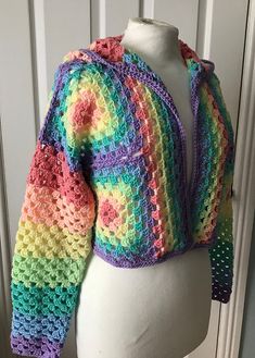 a colorful crocheted jacket is on a mannequin's head,