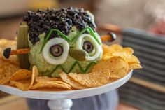 a cake made to look like an alien head with eyes and googly eyes on it