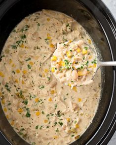 a crock pot filled with chicken and corn soup