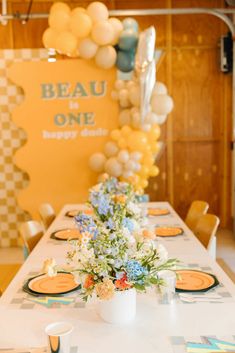 the table is set with flowers and balloons