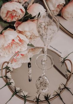 there is a wine glass and some flowers on the table