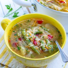 a yellow bowl filled with soup on top of a table