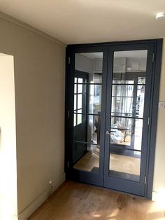 an empty room with glass doors and hard wood flooring