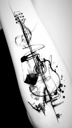 a black and white photo of a guitar tattoo on the right arm with ink splatters