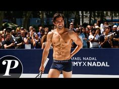 a shirtless man holding a tennis racquet in front of a crowd