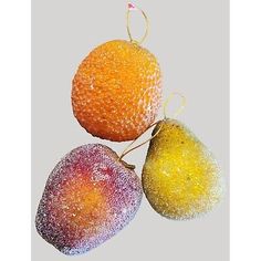 three fruit are hanging on a string with some frosting around the edges and one is orange, yellow, and pink