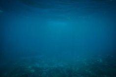 an underwater view of the ocean with blue water