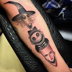 a person with a tattoo on their arm holding a knife and wearing a witches hat