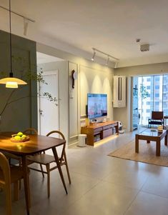 a living room filled with furniture and a flat screen tv sitting on top of a wooden table