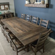 a dining room table with six chairs in front of it and a mirror on the wall