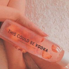 a woman is holding a bottle with liquid on it that says, this could be vodka