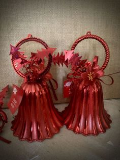 two red tinsel bells with bows on them