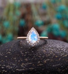 Vintage Moonstone engagement ring Pear shaped Rose gold ring milgrain art deco moissanite ring unique art deco anniversary ring Back to Belloring shop: https://www.etsy.com/shop/BrilliantRing?ref=l2-shopheader-name ---------------------------Specifications---------------------- Engagement ring Center Stone - 6*9mm Moonstone Side stones - 0.323ct Moissanite or Diamond ---------------------------DIMENSIONS----------------------- The Width of the Band - 1.4mm The Thickness of the Band - 1.3mm Weigh Opal Engagement Ring Teardrop, Opal Engagement Ring Pear Shape, Gold Opal Ring Engagement, Pear Shaped Opal Engagement Ring, Teardrop Opal Engagement Ring, Opalite Wedding Ring, Teardrop Opal Ring, Diamond And Opal Ring, Art Deco Wedding Jewelry With Halo Setting