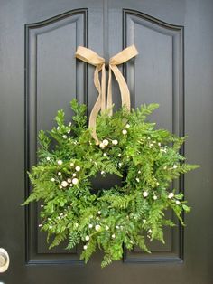 a green wreath hanging on the front door