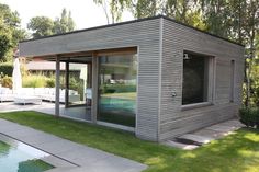 a small house sitting on top of a lush green field next to a swimming pool