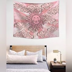 a pink and white wall hanging above a bed