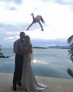 a man and woman standing next to each other in front of a pool