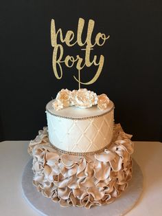 there is a cake that has been decorated with gold letters and ruffles on it