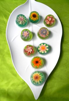 a white plate topped with different types of flowers on top of a green tablecloth