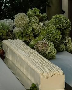 a cake sitting on top of a table covered in flowers