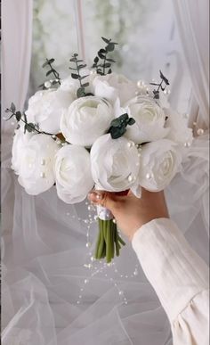 a person holding a bouquet of white flowers