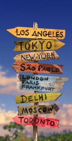 a wooden sign with many different signs on it's sides and the words los angeles, tokyo, new york, san francisco