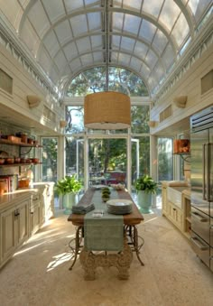 a large kitchen with an arched ceiling and glass doors leading to the dining room area