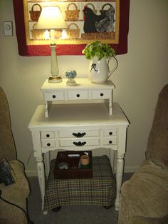 a small white table with drawers underneath a lamp