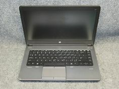 an open laptop computer sitting on top of a white counter next to a black mouse