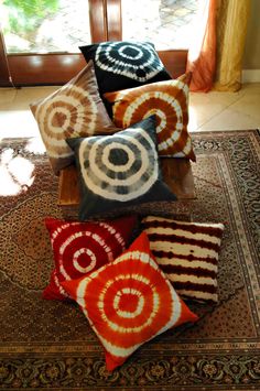 four decorative pillows sitting on top of a rug