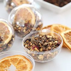 orange slices and granola in plastic containers on a table with other food items around them