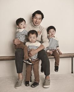 a man sitting on a bench with three children