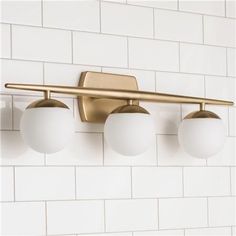 three light bathroom fixture with white glass balls on the bottom and gold fixtures above it