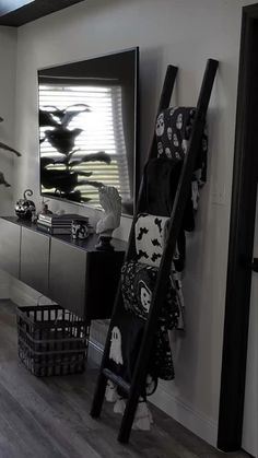 a black and white photo of a living room with a ladder leaning against the wall