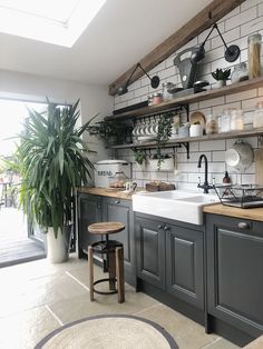 a kitchen filled with lots of pots and pans next to a sink under a window