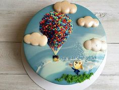 a cake decorated with an image of a hot air balloon floating in the sky and clouds