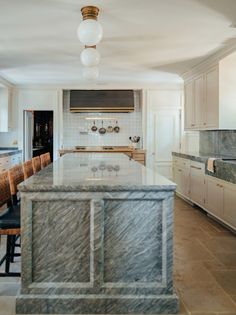 a kitchen with marble counter tops and an island in the middle of the room,