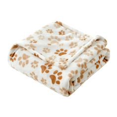 a white and brown dog paw print blanket on top of a white background with orange spots