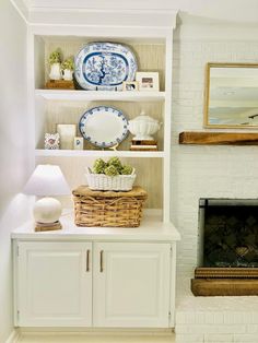 a living room filled with furniture and a fire place in front of a white brick wall