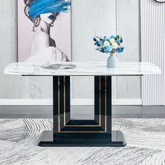 a white marble table with blue flowers in a vase on top and a painting behind it