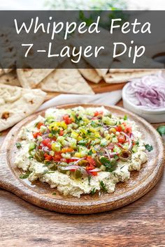 a pizza topped with vegetables on top of a wooden cutting board next to tortilla chips