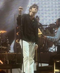 a man standing next to a microphone on top of a stage