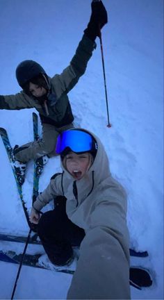 two people in the snow with skis and poles