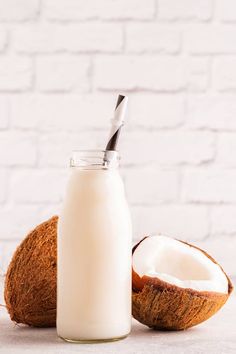 a bottle of milk next to a half eaten coconut