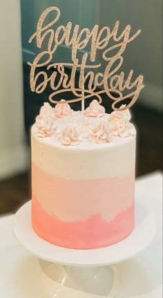 a pink and white cake sitting on top of a table